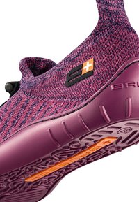 Różowo-fioletowe sportowe buty dziewiarskie z formowaną gumową podeszwą, z pomarańczowym akcentem i czarną łatą z logo po boku.