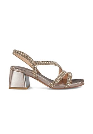 Sandalias de tacón tipo slingback en bronce metálico, con tiras cruzadas decoradas con cristales y un tacón cuadrado grueso.