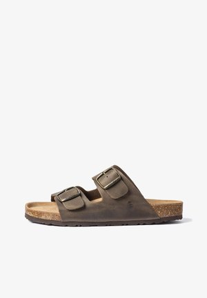 Brown suede slide sandal with two wide adjustable straps and metal buckles on cork sole with textured rubber outsole.