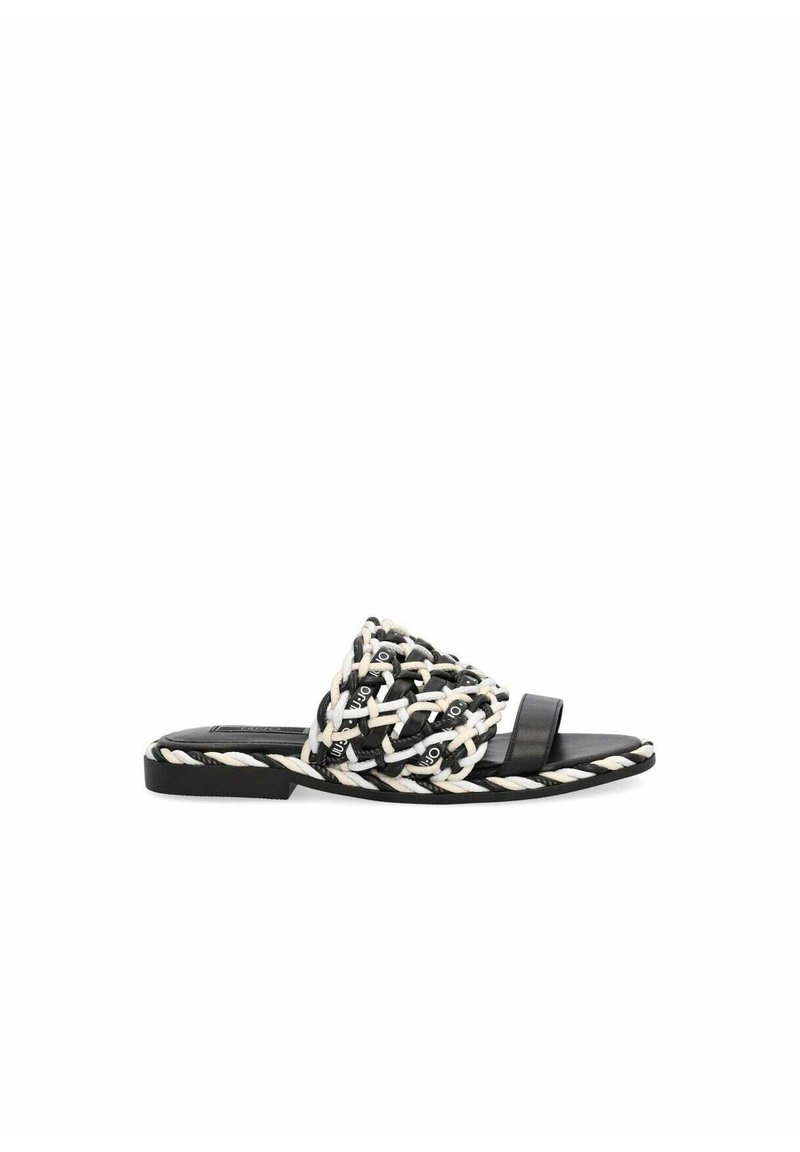 Sandal in cuoio intrecciato bianco e nero con una parte superiore in tessuto intrecciato e una suola liscia. Presenta un tacco basso e un design minimalista.