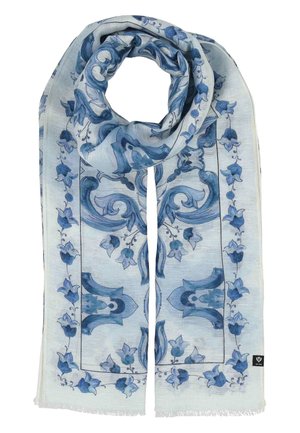 Šviesiai mėlynas šalikas su tamsiai mėlynomis gėlių ir ornamentinėmis raštais, laisvai sulankstytas kilpa su kutais kraštuose ir maža juoda etikete.