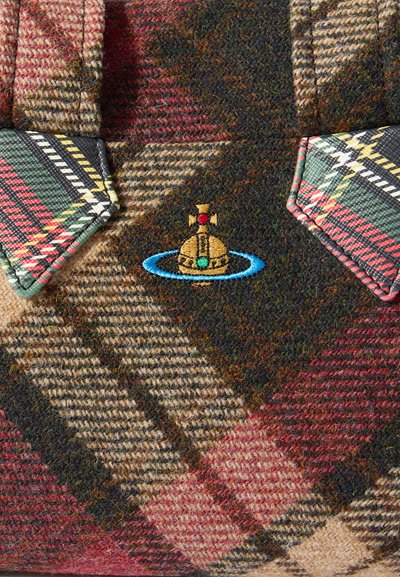 Pleds vilnas audums ar sarkaniem, zaļiem un bēšiem toņiem un teksturētu rakstu. Redzams izšūts dizains ar kupolveidīgu objektu, riņķiem un krāsainiem akcentiem.