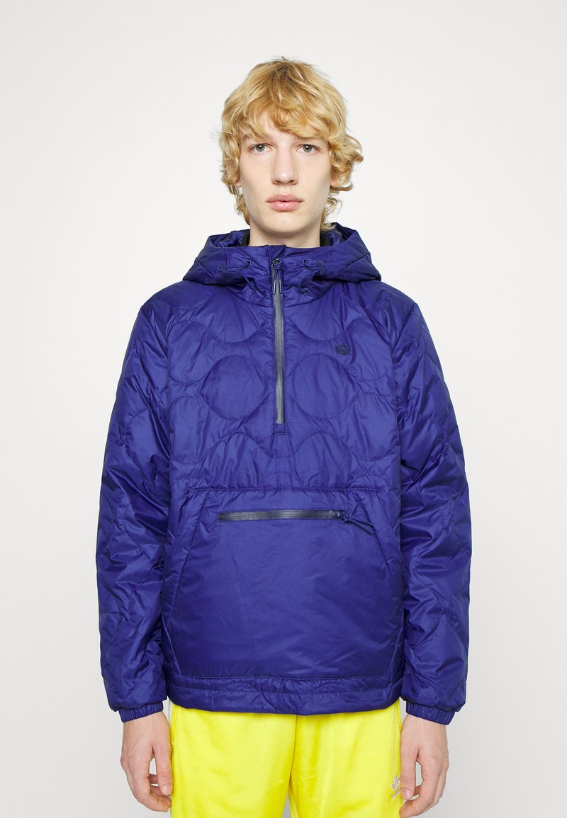 Giacca puffer blu con cappuccio, dotata di un'apertura frontale con mezza zip e una tasca con zip. I pannelli testurizzati creano un motivo trapuntato.