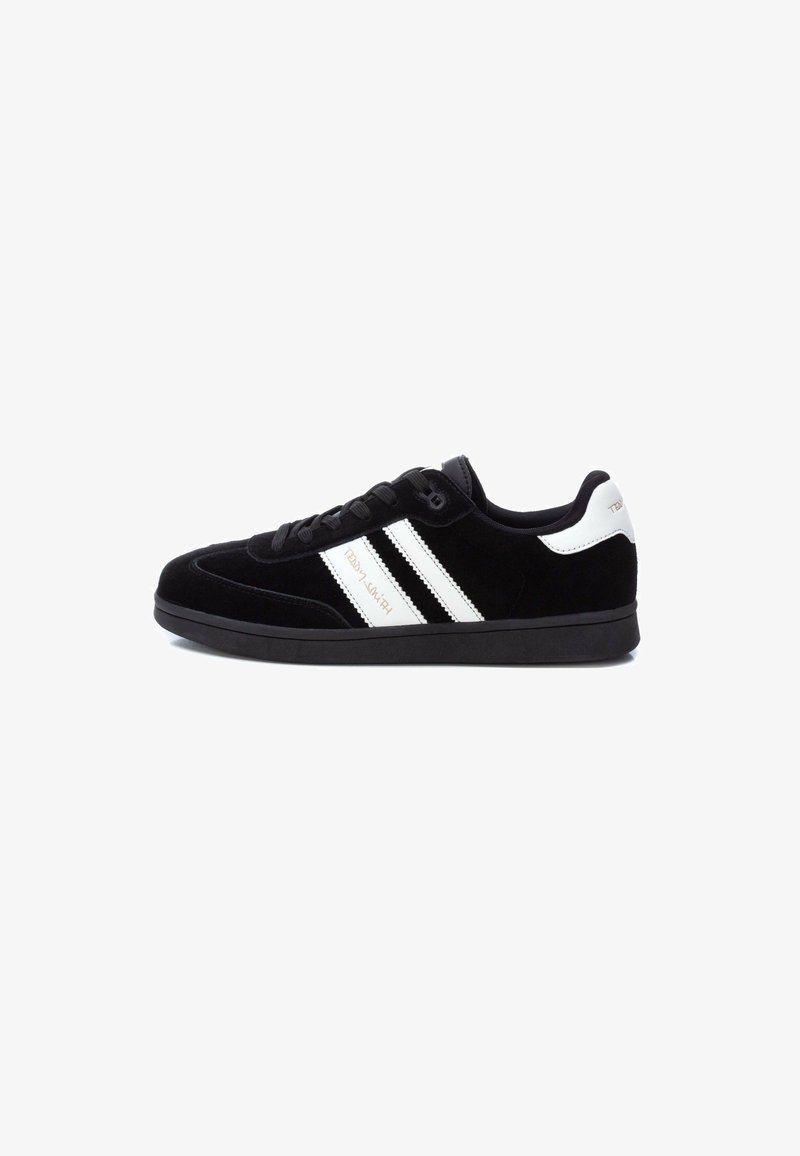 Zapatilla de ante negra con punta redonda, franjas laterales blancas, cierre con cordones y suela de goma negra texturizada.