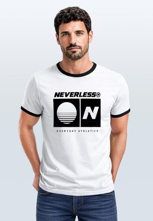 Mann mit dunklem lockigem Haar und Bart, der ein weißes T-Shirt mit schwarzem Rand und "NEVERLESS Everyday Athletics"-Logo trägt und nach vorne schaut.