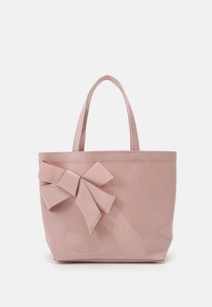 Petit sac à main rose brillant avec deux anses et un grand nœud décoratif sur le devant à gauche.