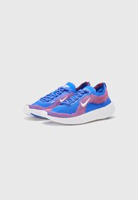 Blå og pink atletiske sko med en åndbar strikoverdel, hvid sål og kontrasterende snørebånd. Har et logo på siden og et struktureret design.
