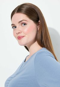 Top blu di cotone a maniche corte con scollatura rotonda, realizzato in un tessuto morbido. Presenta una leggera trama e dettagli cuciti lungo la parte anteriore.