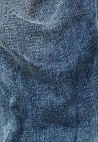 Denimtyg som visar en textur i olika nyanser av blått, med ett klassiskt twill-vävmönster och subtila slitage märken samt en mjuk yta.