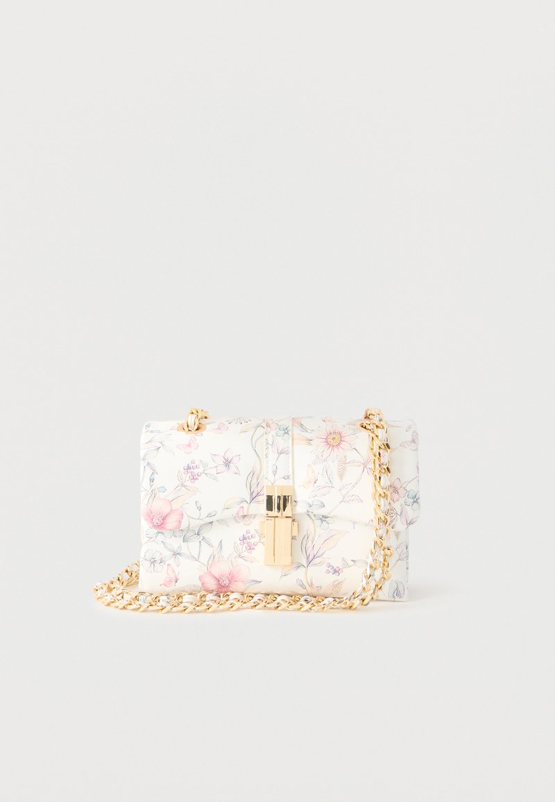 Pequeño bolso blanco con patrones florales en rosa y azul, cierre dorado y correa de cadena dorada sobre fondo blanco liso.