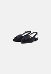 Sötétkék nubuk anyagú slingback cipők, kerek orral, lapos sarokkal és nagy díszes masnival az elején. Állítható bokapánt.