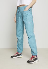 Light blue, lightweight outdoor pants with multiple pockets and elastic cuffs, paired with gray and black athletic shoes featuring red accents.