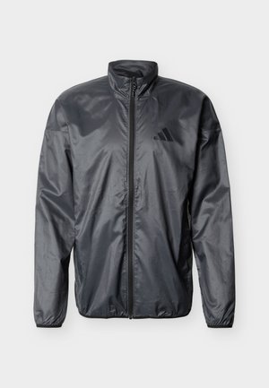 Schwarze, leichte Jacke mit durchgehendem Reißverschluss, hohem Kragen, langen Ärmeln, elastischen Bündchen und unauffälligem Markenlogo auf der linken Brust.