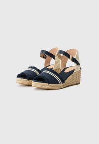 Námořnické modré espadrilky na platformě s třepenými textilními svršky, bílými pruhy, tkanými juty a nastavitelnými pásky kolem kotníků.