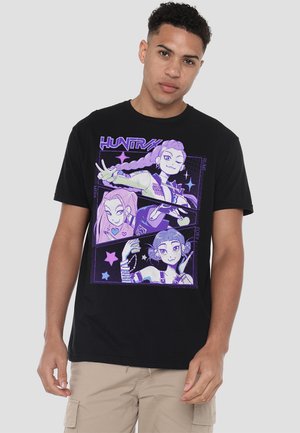 Black t-shirt featuring a purple graphic with three cartoon characters, stars, and text "HUNTRAX". Short sleeves and crew neckline.