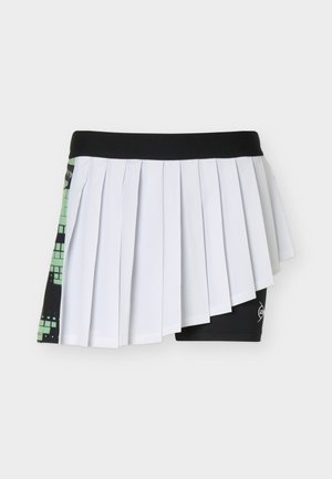 Černá tenisová sukně s bílými předními sklady, pod ní černé přiléhavé šortky a zelený vzorovaný panel na levé straně.