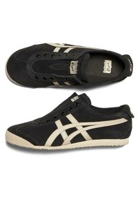 Baskets basses Onitsuka Tiger noires et beige sans lacets, une vue de côté et l'autre de dessus.