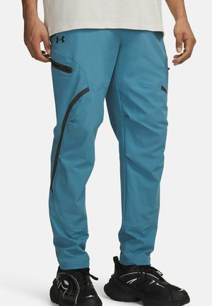 Lichtblauwe sportbroek met zwarte accenten, zakken met rits en een taps toelopend ontwerp. Gemaakt van rekbare, ademende stof.