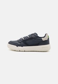 Sneaker in pelle blu navy con suola in gomma bianca, accenti testurizzati, perforazioni e dettaglio del tallone grigio a contrasto. Lacci dello stesso colore.