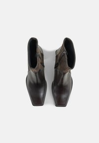 Brown leather ankle boots with a smooth texture, square toe, and side zippers; features a contrasting darker suede upper section.