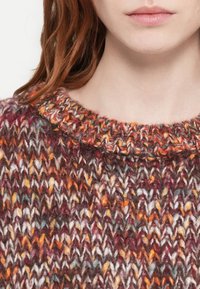 Strikket genser med rund hals i flerfarget garn som har nyanser av brunt, oransje, krem og teal, med et strukturert mønster.