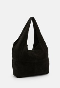 Black suede tote bag with two long handles, soft texture, and a curved shape. Features a prominent seam at the base for structural design.