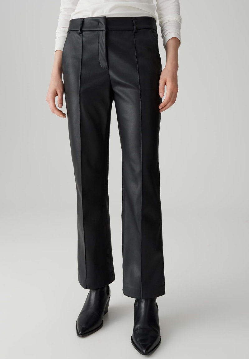 Pantalon en cuir noir à jambe droite avec une texture lisse, doté d'une fermeture éclair à l'avant et de coutures latérales contrastées pour un détail supplémentaire.