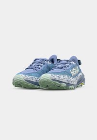 Baskets de sport bleues avec une tige texturée, semelle à motifs blancs et verts, et une languette à l'arrière pour un enfilage facile.