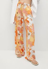 Pantalon à motifs floraux dans des tons orangés, roses et jaunes ; fabriqué en matière légère ; coupe décontractée avec taille à cordon ; design à jambes larges.