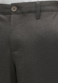 Σκούρο γκρι υφασμάτινο παντελόνι με κουμπί και θηλιά για ζώνη στη μέση.