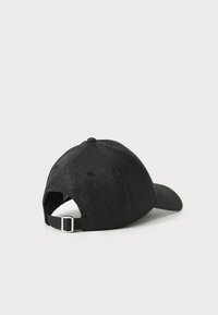 Svart caps med en strukturert form, teksturert stoff, justerbar stropp bak og en rund skygge. Har subtile pregete mønstre.