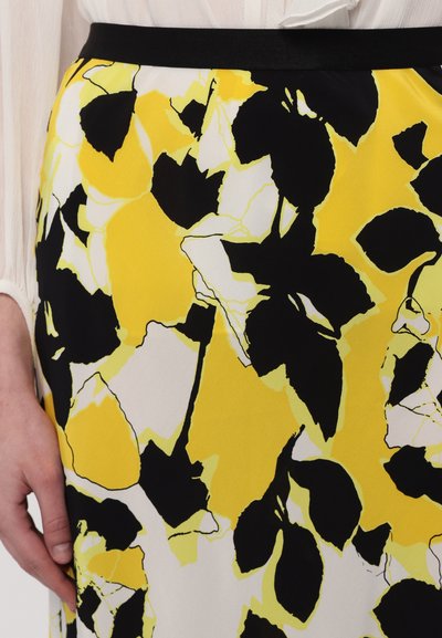 Floral skirt featuring a bold yellow, black, and white pattern; lightweight fabric with a smooth texture and a black waistband.