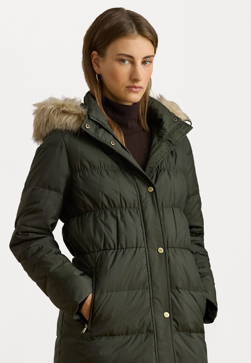 Zelená vypchávkovaná bunda s kapucňou umelým kožúškom, zlatými gombíkmi a bočnými vreckami. Obsahuje prešívanú textúru a vysoký golier.