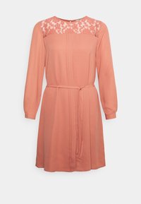 Vestido de cor pêssego com detalhes em renda no corpete, mangas longas e um cinto atado na cintura. Tecido suave com um design fluido.