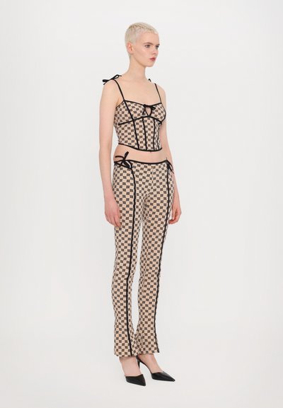 Rutet mønster to-delt sett med en tettsittende crop top med skulderbånd og høyt liv bukser med sidene detaljer, komplementert av svarte hæler.