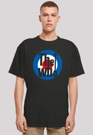 Black cotton t-shirt featuring a circular logo with blue, white, and red elements and the text "The Who" in bold black letters.