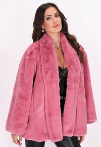 Cappotto in pelliccia sintetica di un brillante colore rosa, con un ampio colletto e maniche oversize. La texture è morbida e pelosa, aumentando calore e comfort.