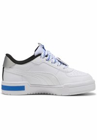 Zapatilla blanca con cuero texturizado, acentos negros, detalles azules y cordones con patrón. Presenta una suela plana y un diseño de punta redondeada.