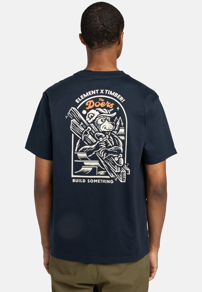 Navyblaue Baumwoll-T-Shirt mit einem Bärenmotiv, das Werkzeuge und ein Bergdesign auf der Rückseite zeigt. Der Text lautet "ELEMENT X TIMBER! BAU DIR WAS".