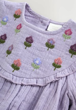 Violetinė suknelė siuvinėtomis gėlėmis rožinės, violetinės ir mėlynos spalvų. Turi raukšlėtą apykaklę ir tekstūruotą audinį, tinkama kūdikiams.