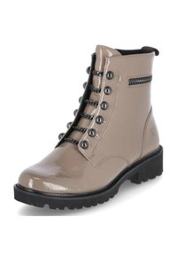 Stivale alla caviglia in vernice beige con punta arrotondata, suola in gomma nera, borchie in metallo e lacci, dotato di zip laterale per una facile vestibilità.