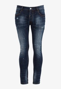 Úzké džíny z tmavě modrého denimu s opotřebovanými detaily, jemnými barevnými skvrnami a kontrastním šitím. Mají pět kapes a zapínání na knoflíky.