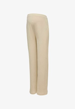 Luźne beżowe dzianinowe spodnie z elastycznym paskiem w talii, na białym tle.