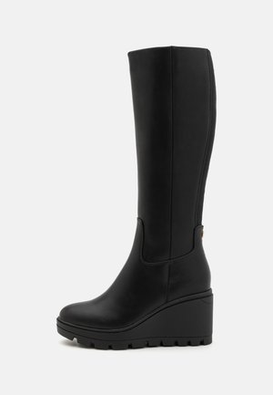 Black knee-high wedge boots made of smooth leather with a textured rubber sole, featuring a sleek design and a subtle side accent.
