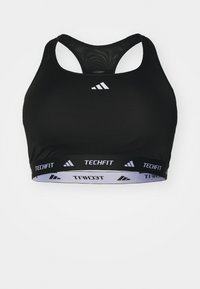 Črna športna modrček z mrežastim oblikovanjem na hrbtni strani. Ima bel pas z logotipom "TECHFIT" na dnu in logotip adidas spredaj.