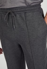 Grijze, zachte stof joggers met een elastische tailleband met trekkoord, zijzakken en gestructureerde naden voor een verzorgde uitstraling.