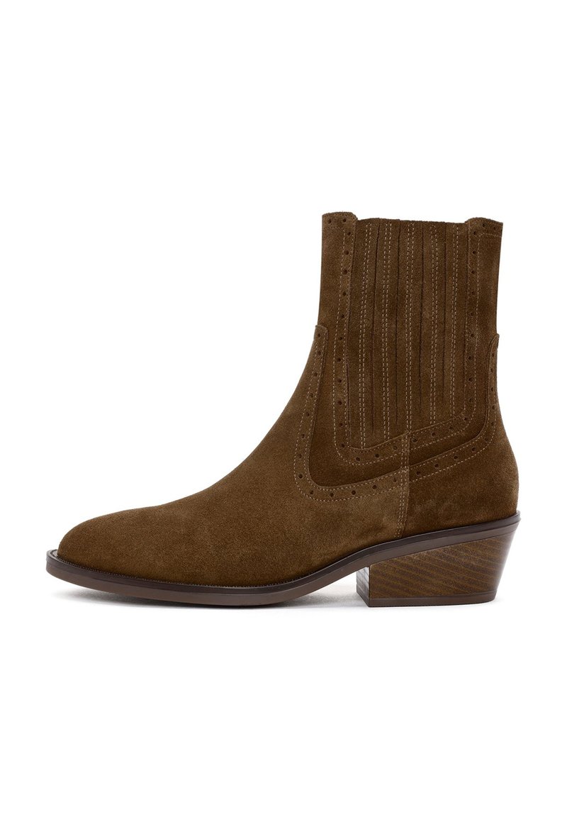 Brown suede ankle boot with a pointed toe, stacked heel, and vertical stitching detailing along the sides. Textured brown heel adds dimension.