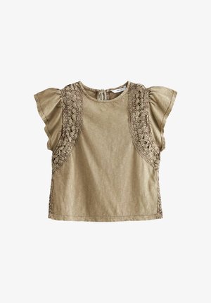 Krótki rękaw, jasnobrązowa bluzka wykonana z miękkiego materiału, z koronkowymi zdobieniami na ramionach i zapięciem z tyłu na kluczowe oczko.