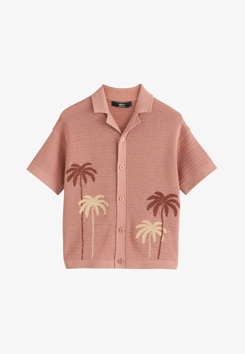 Chemise en maille à manches courtes avec boutons, de couleur rose poudré, ornée de motifs de palmiers en crème et marron sur le devant.