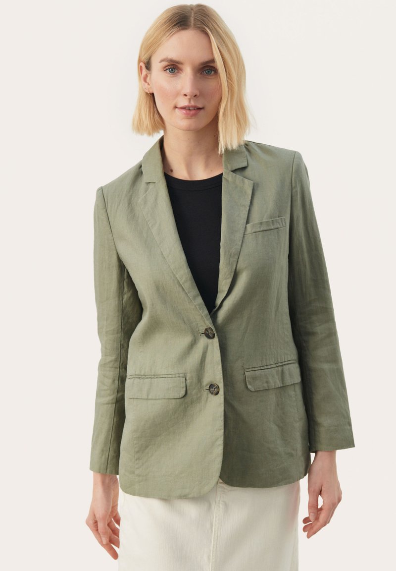 Olivově zelený lněný blazer s klopovým límcem, dvěma předními kapsami a dvěma knoflíky. Rukávy jsou dlouhé a mírně přiléhavé.